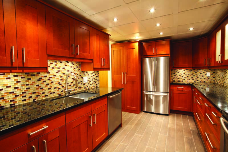 Kitchen with red cabinets and stainless steel appliances.